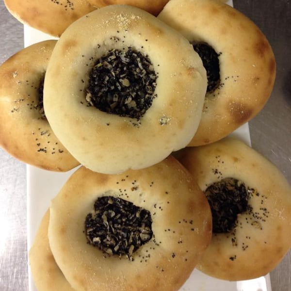 New York Bagel Cafe's savory bagels with dark, chunky filling and poppy seeds.