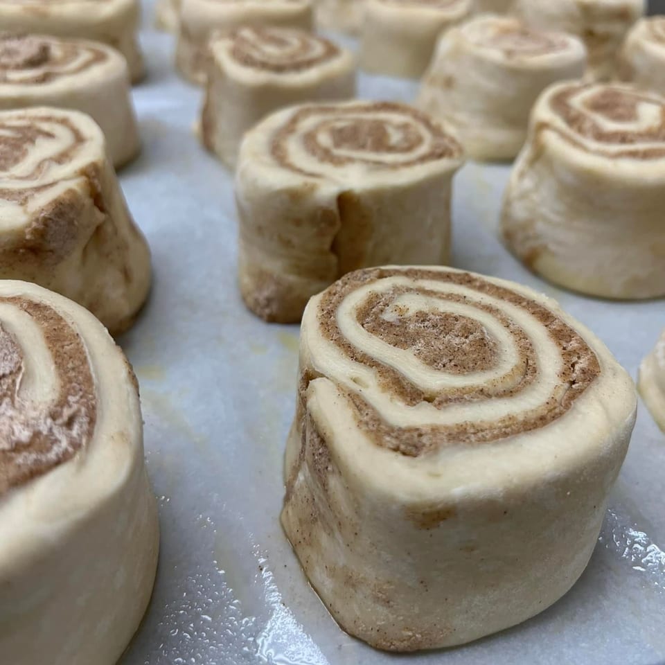 Rows of New York Bagel Cafe cinnamon roll dough, ready for baking.